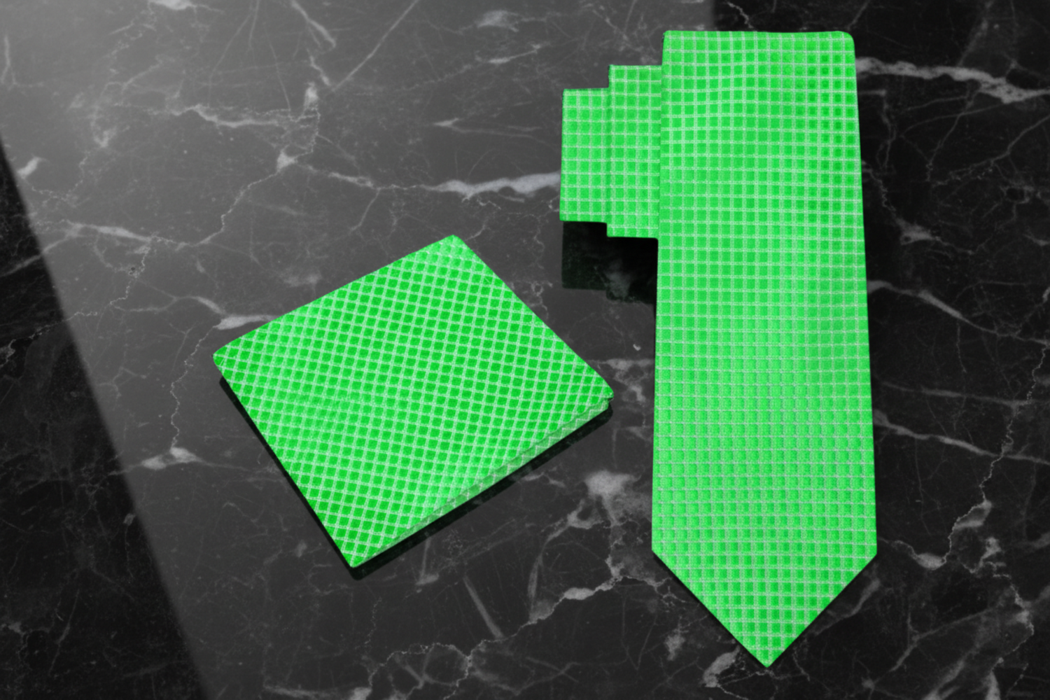 Green checkered tie and pocket square set on a grey background