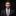 Man wearing a suit with a patterned tie against a black background
