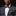 Man wearing a gray suit with a brown bow tie and pocket square on a black background