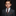 Young boy in a formal gray suit with a patterned tie against a dark background