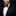 Man wearing a black suit with a red polka dot bow tie and pocket square against a dark background