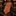 A rolled and laid-flat necktie with a herringbone and grid pattern in orange, red, and brown tones, displayed on a polished black marble surface in a warm, upscale interior setting.