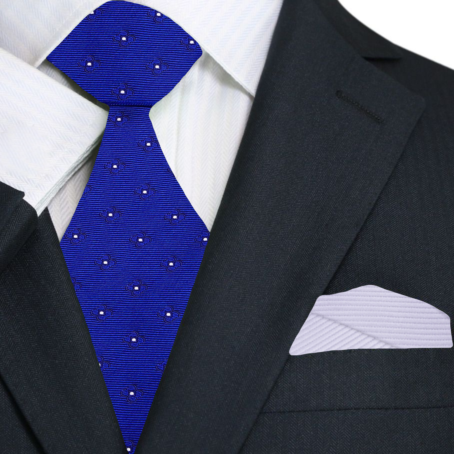 Man wearing a gray suit with a blue tie and white square against a black background