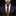 Man wearing a black suit with a patterned orange tie and pocket square against a dark background