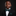 Young boy in a formal black suit with a green bow tie and pocket square on a dark background