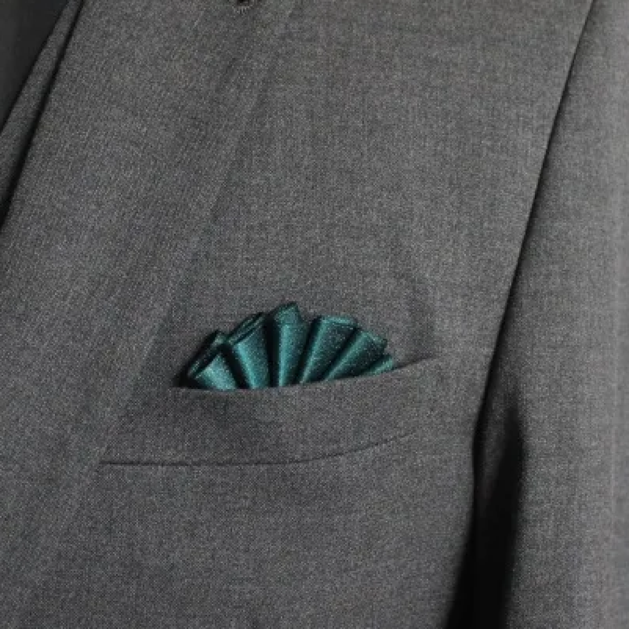 Gray suit jacket with a teal pocket square