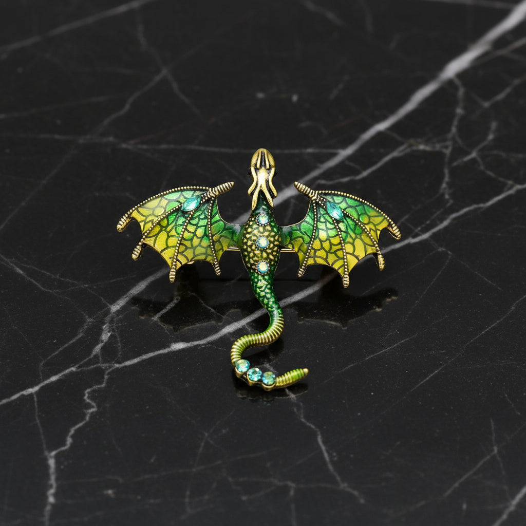 Green dragon-shaped brooch with gold accents on a white background