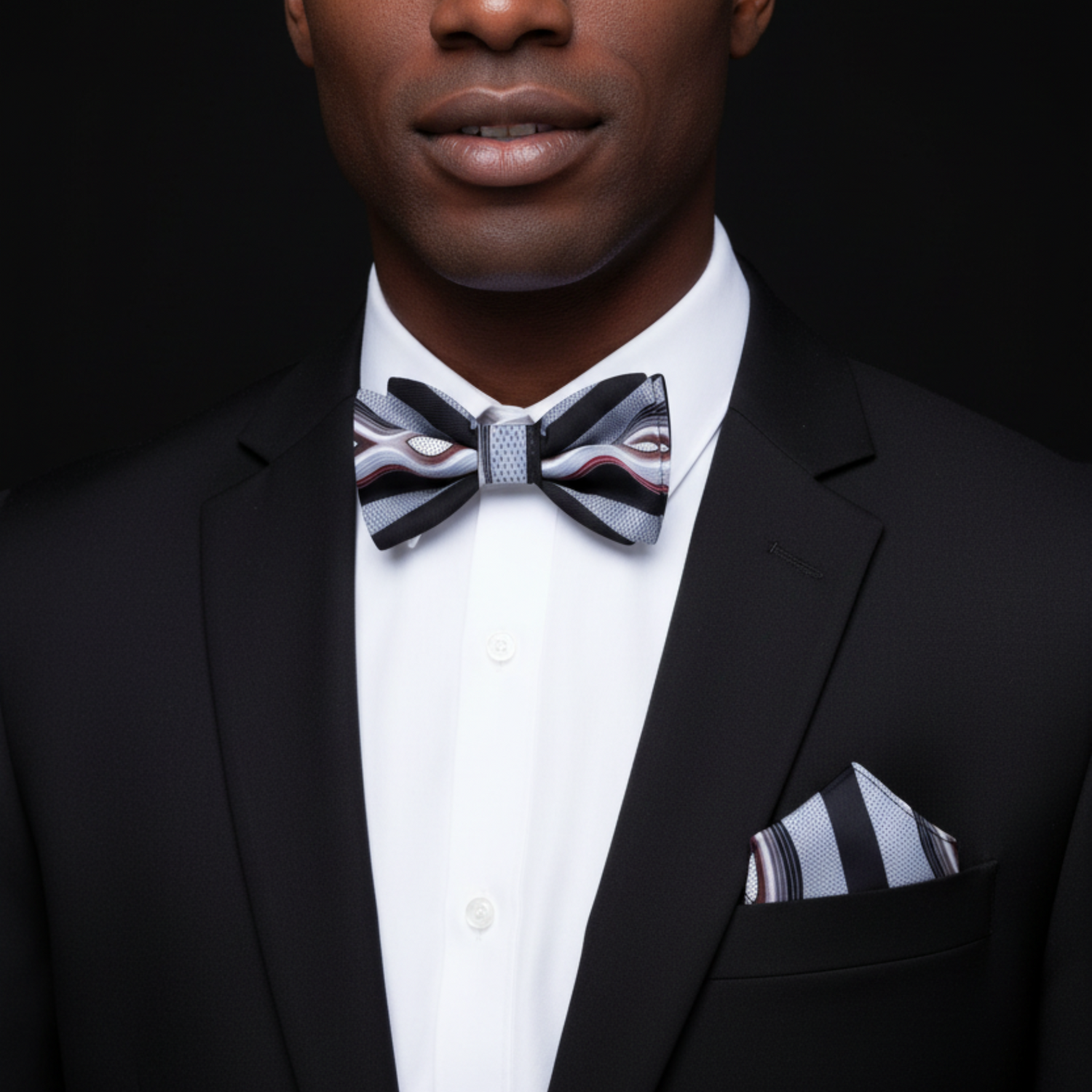 Man wearing nice suit and grey with black bow tie and matching square