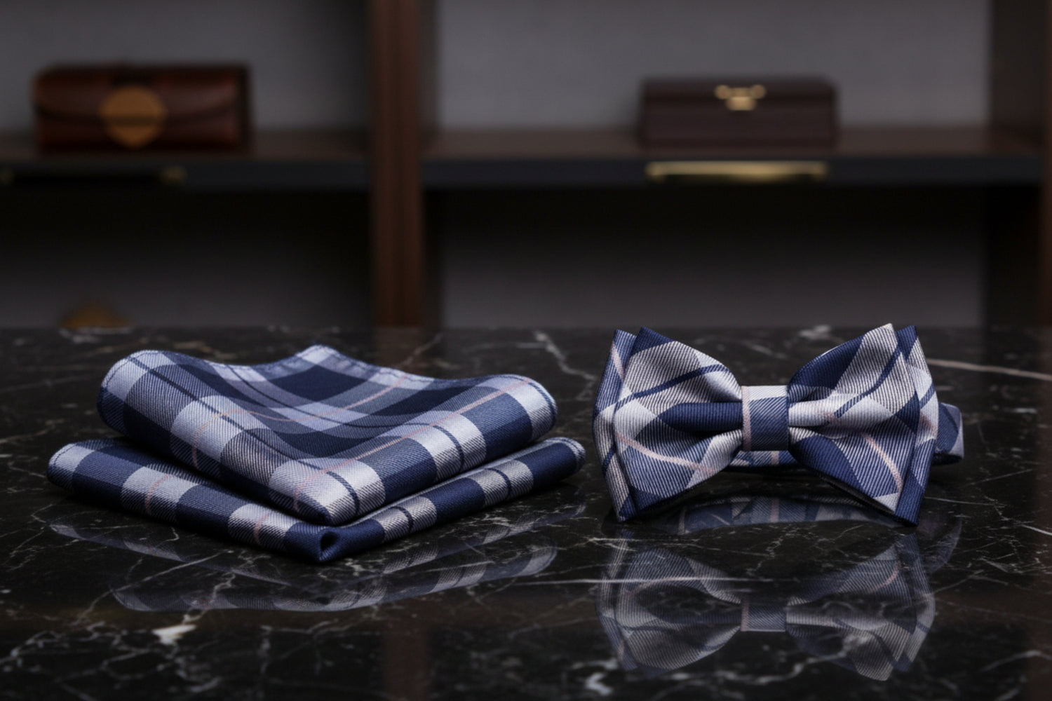 A matching men's formal accessory set featuring a plaid necktie and a matching pocket square in navy blue, gray, and white, displayed on a clean white background.