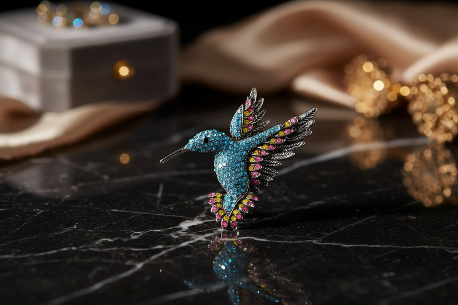 Decorative hummingbird brooch with colorful gemstones on a marble background