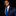 Man wearing a navy suit with a blue striped tie and pocket square on a black background