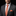 Man wearing a gray suit with an orange tie and pocket square on a black background