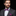 Man wearing a gray suit with a colorful bow tie and pocket square on a black background