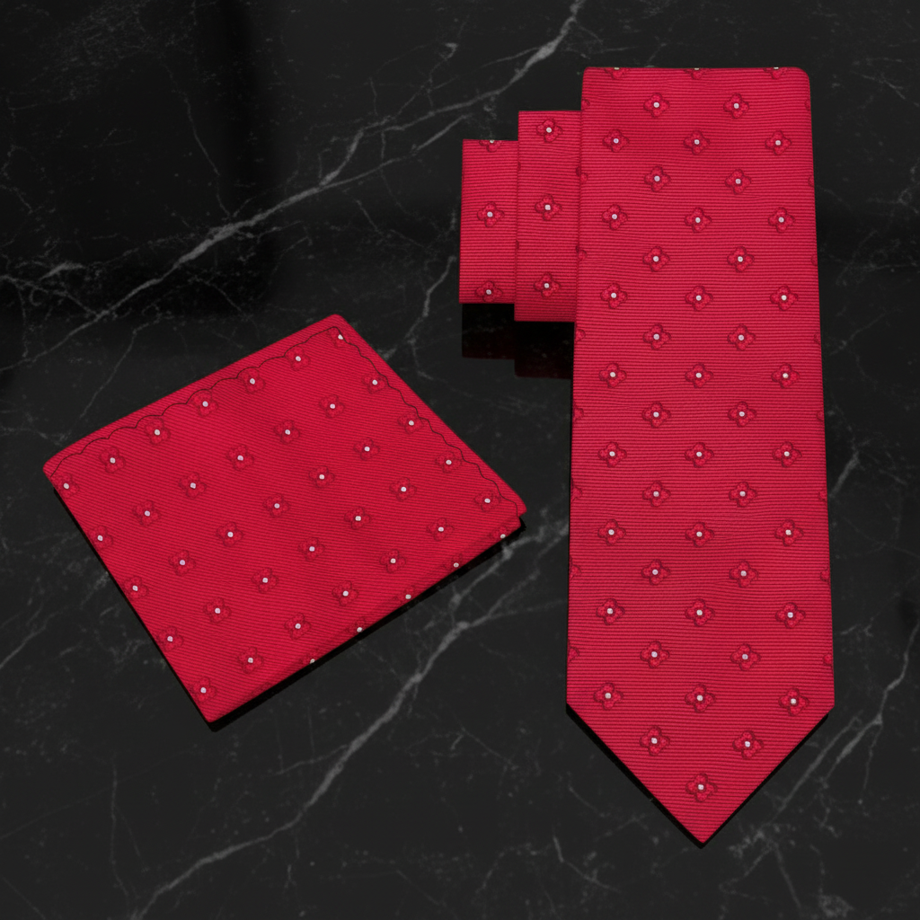 Red tie and matching pocket square with a subtle pattern on a marble surface