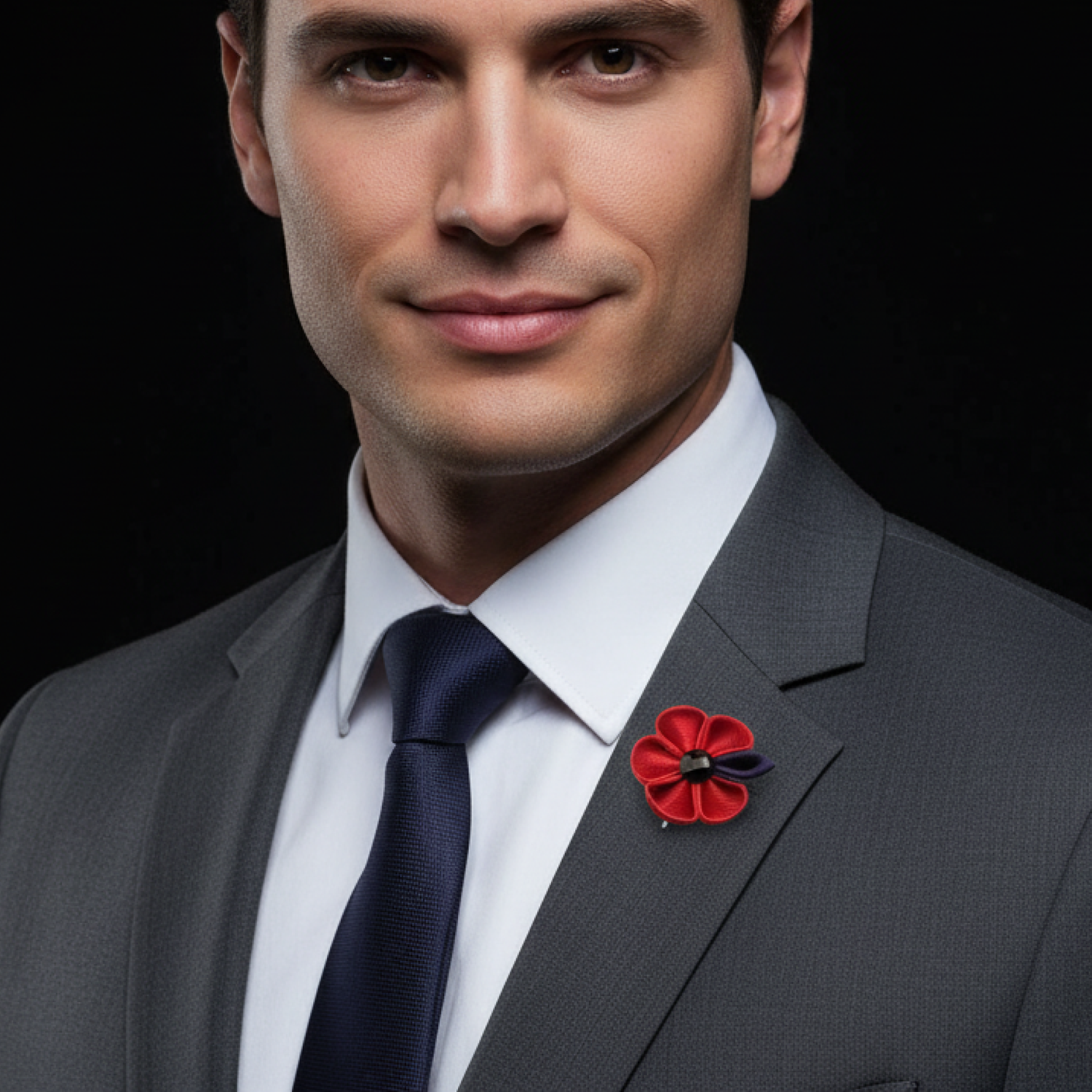 Man wearing a gray suit with a red flower pin on a black background