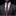 Man wearing a gray suit with a red paisley tie and pocket square against a black background