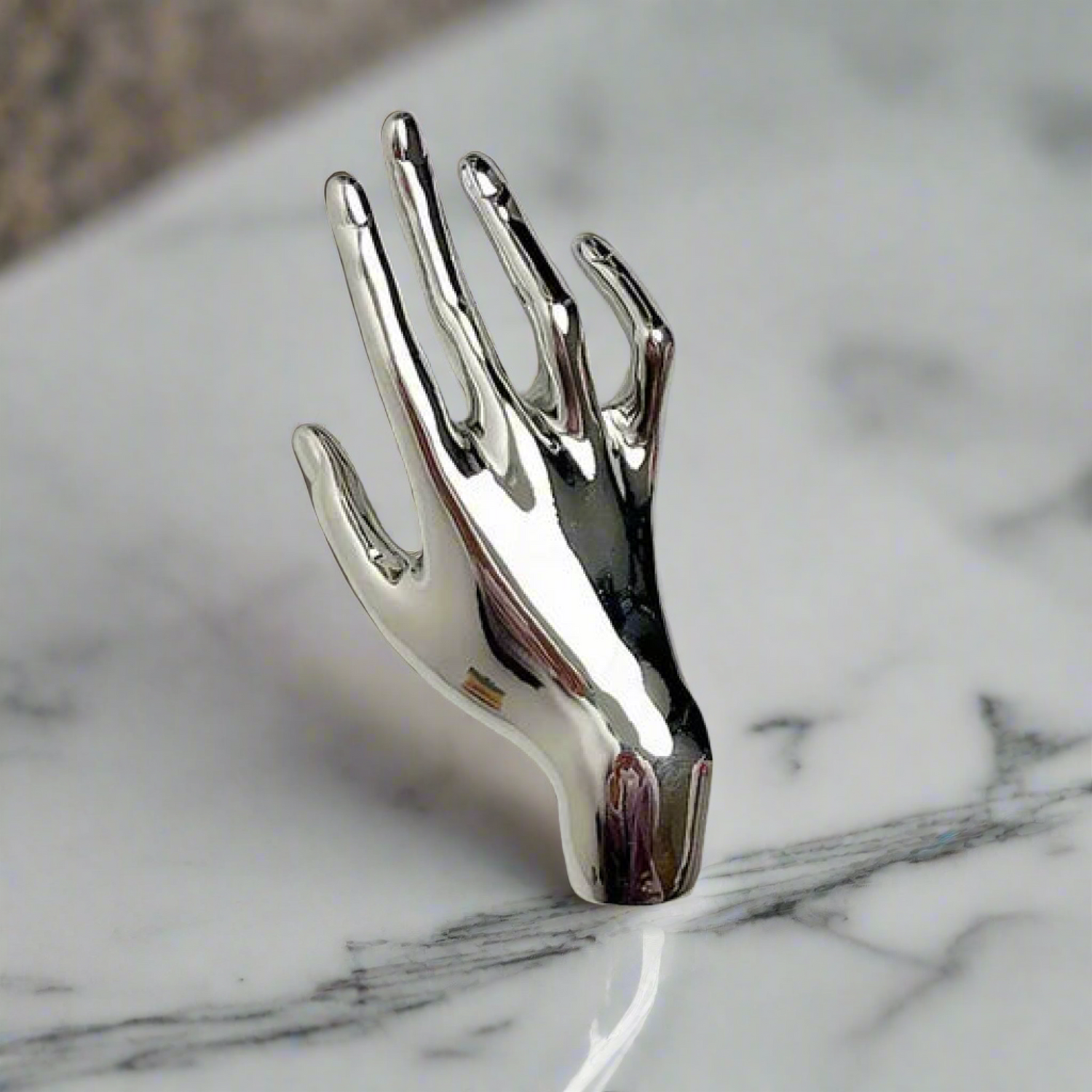 a silver hand lapel pin