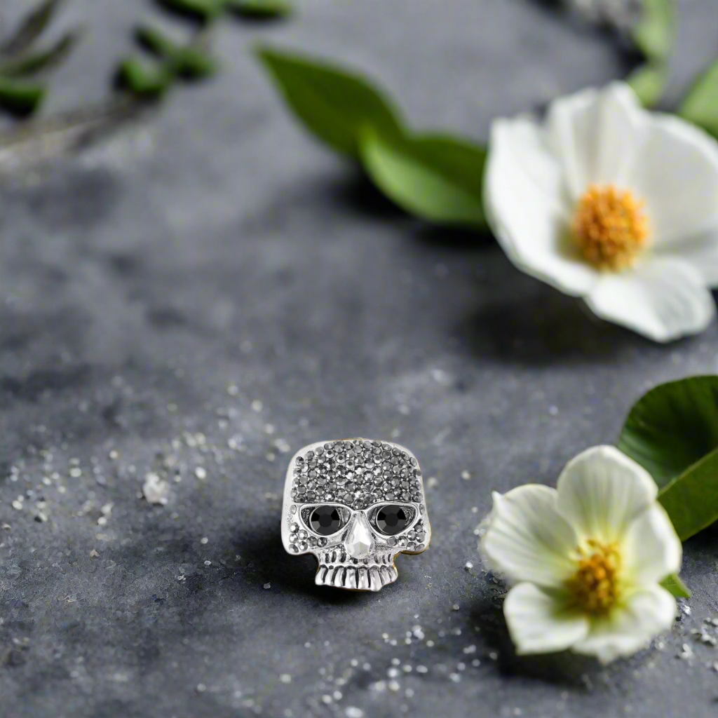 main a small chrome lapel pin with a skull shape