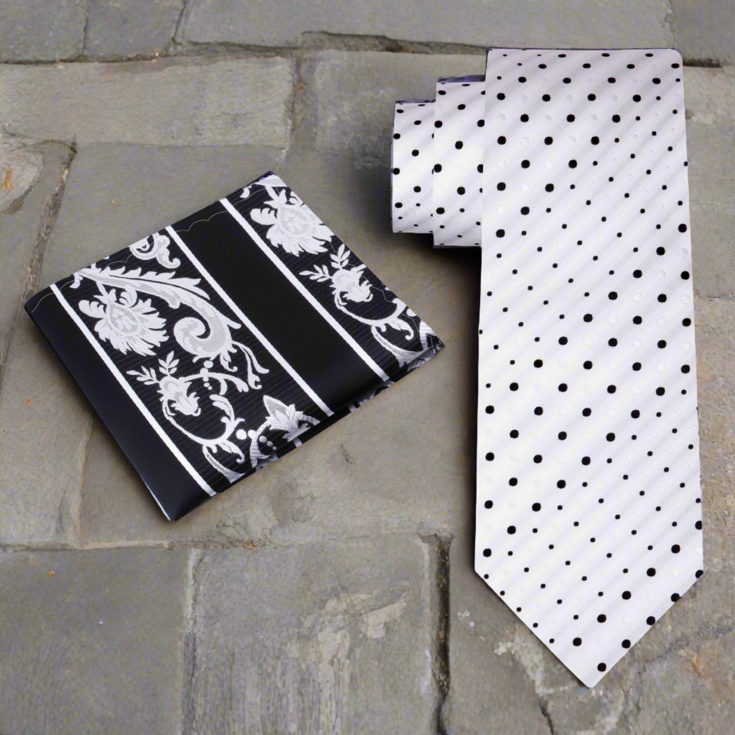 A white and black dots necktie and accenting black and grey paisley square