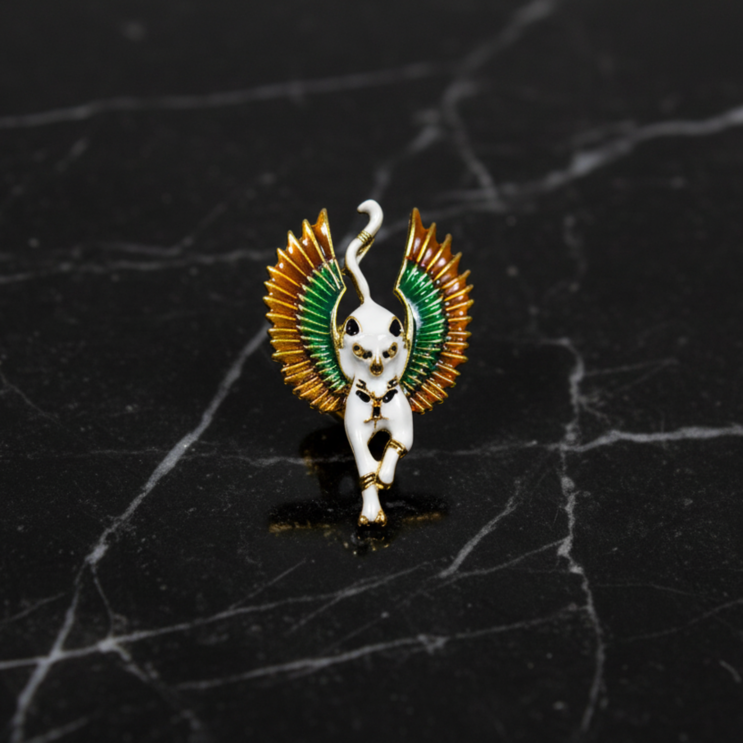 Decorative angel figurine lapel pin with green and gold wings on a white background 