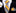 Yellow and gray striped tie with matching pocket square and cufflinks on a black suit.