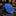 A rolled necktie with a vibrant abstract pattern in blue, pink, and purple, displayed on a polished black marble surface inside a luxury retail store.