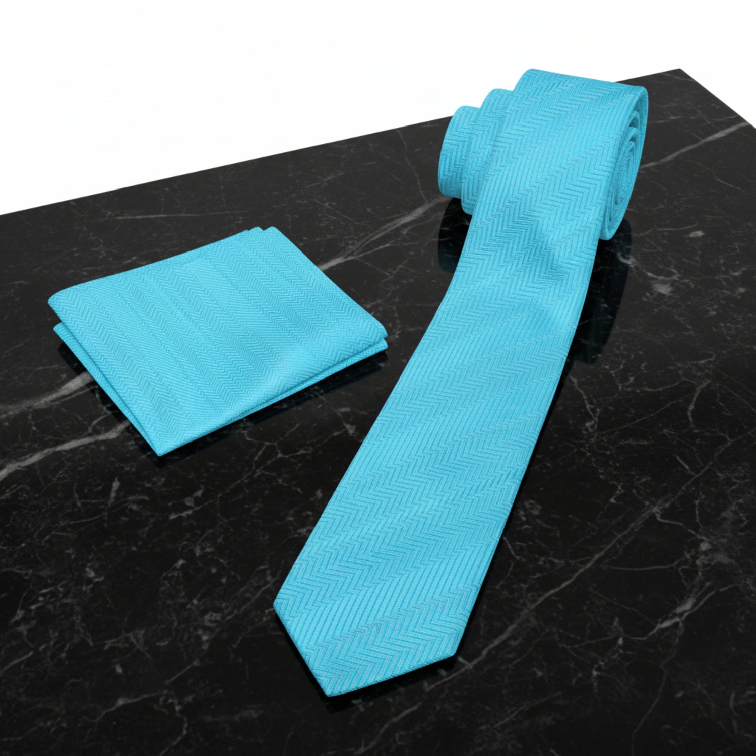 A light blue necktie and matching pocket square set with a subtle herringbone pattern, displayed on a clean white background.