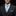 Man wearing a black suit with a blue tie against a black background