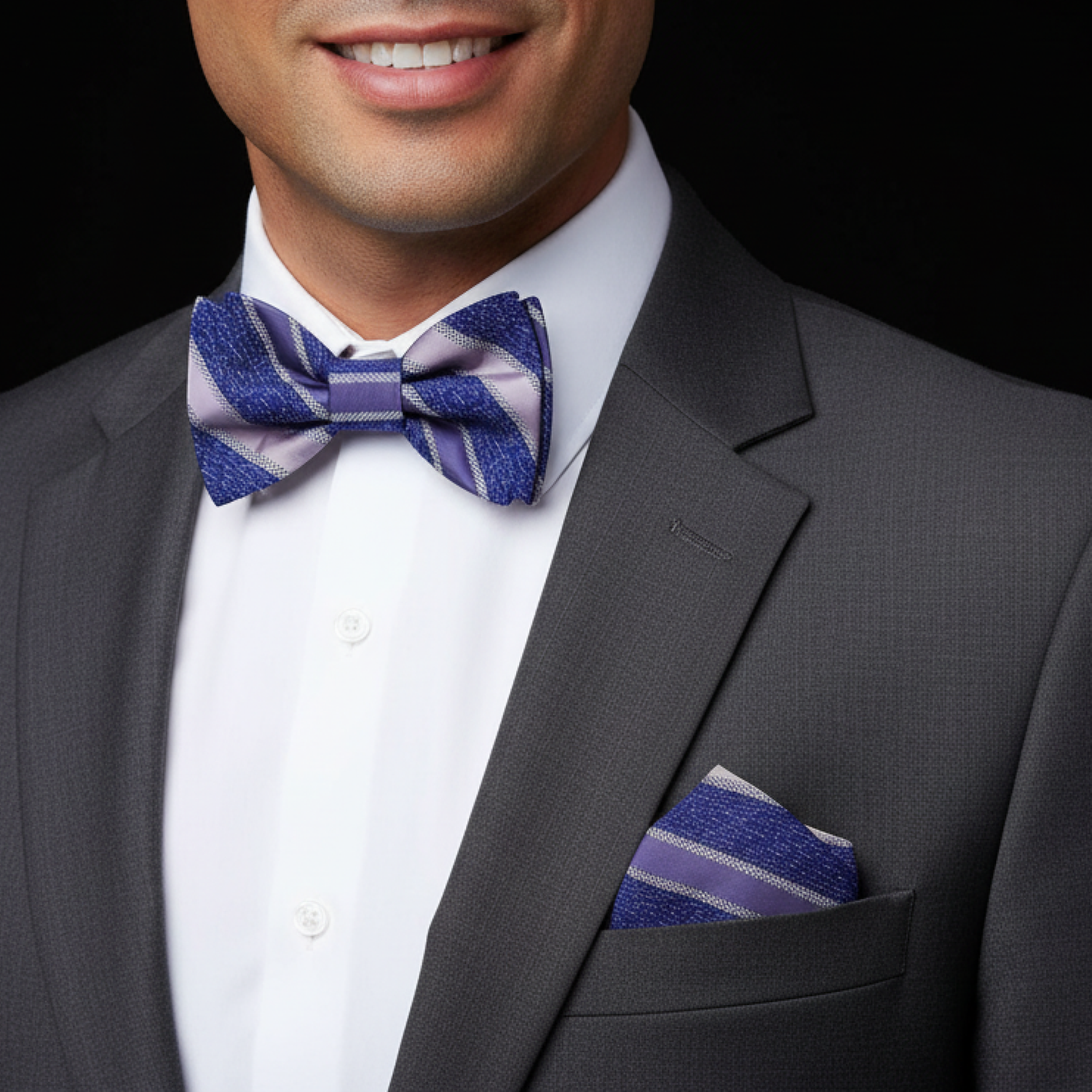 grey suit with a blue and purple stripe bow tie and pocket square