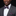 Man wearing a gray suit with a red bow tie and pocket square on a black background