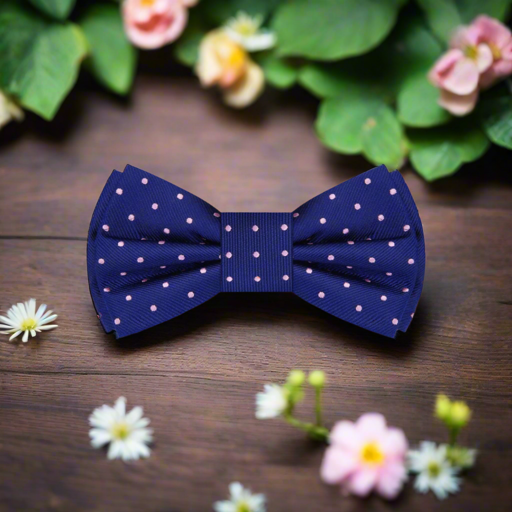 A blue and pink polka dot bow tie on peach design background