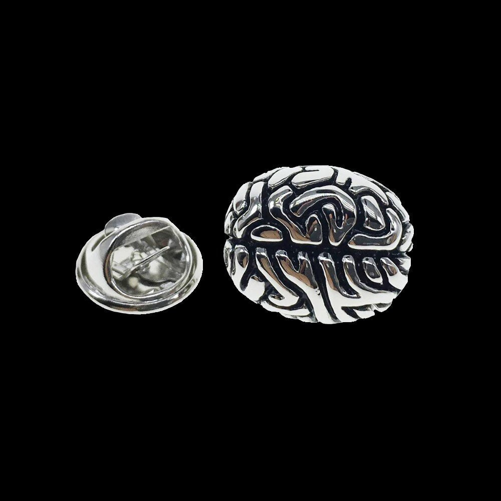A chrome colored brain shaped lapel pin