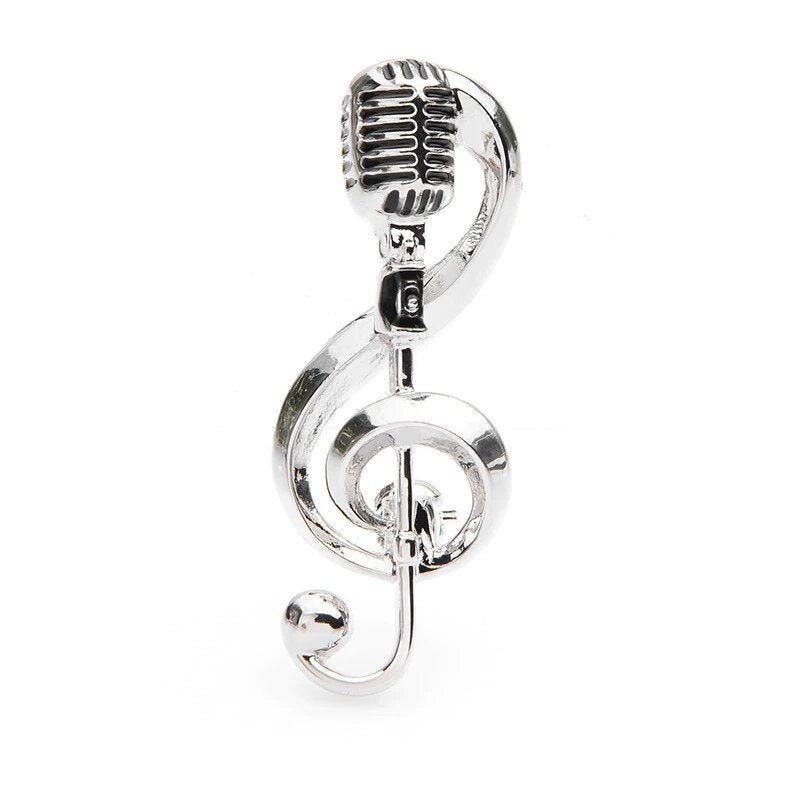 A Silver Colored Lapel Pin Shaped Like A Music Note With A Microphone