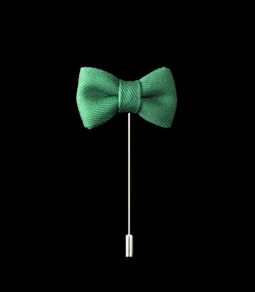 A Green Colored Bow Tie Shaped Lapel Pin||Green