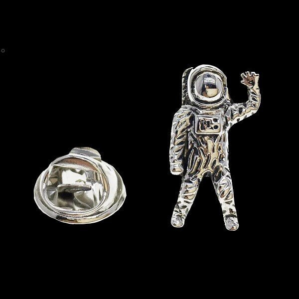 A chrome colored astronaut shaped lapel pin