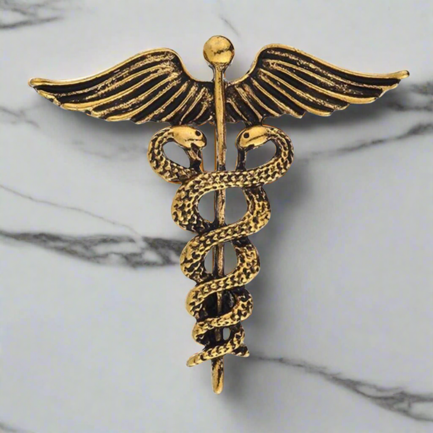 Main View: A Gold Colored Caduceus Shaped Lapel Pin